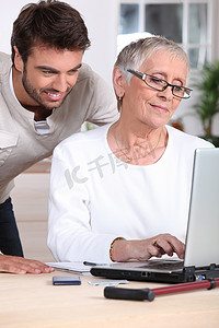 家庭用电摄影照片_帮助老太太用电脑的男人