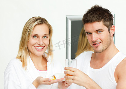 拿着药丸的女人和拿着一杯橙汁的男人