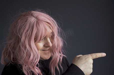 一个戴着粉红色假发的男人的画像，一边看着一边用手指指着一边。