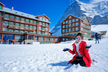 穿着红色外套在户外玩雪的漂亮年轻女人