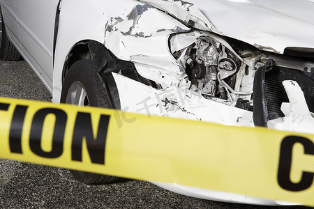 事故现场警告胶带后面一辆破损汽车的特写