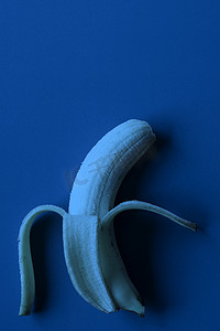 蓝纸背景中的香蕉，深蓝色调图像