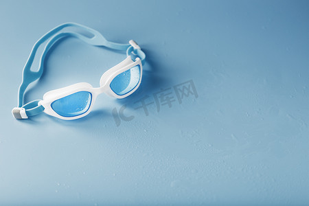 游泳镜摄影照片_蓝色背景中白色框架中的游泳镜