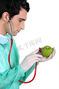 医生用听诊器检查苹果