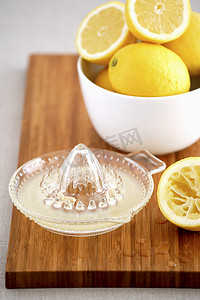 砧板上的一碗柠檬和榨汁机
