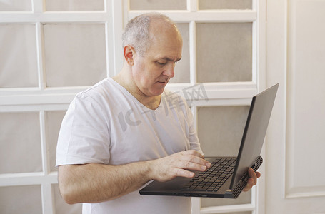 一个男人手里拿着一台笔记本电脑，写了一条消息。