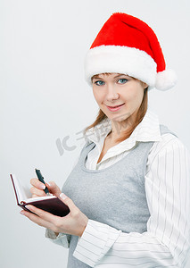 带帽的女人摄影照片_带笔记本的女人戴着圣诞帽
