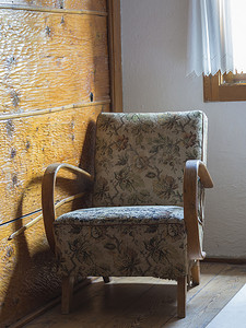 有窗背景摄影照片_窗下有花卉图案的旧软垫木制扶手椅
