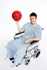 坐在轮椅上拿着篮球的病人