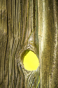 带孔的旧木板，可以看到黄色背景