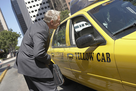 出租车司机摄影照片_资深商人与出租车司机讨论他的票价