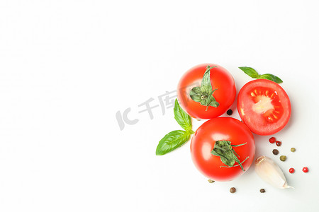 白色背景中带有罗勒、胡椒和大蒜的新鲜樱桃西红柿、文字空间和顶视图。