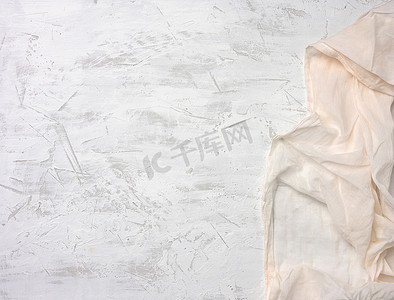 灰色水泥背景上的白色纺织厨房餐巾