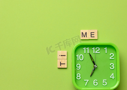 绿色背景上的方形绿色闹钟和题字时间
