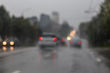 雨后夜间街道汽车交通的散焦图片-从道路看。