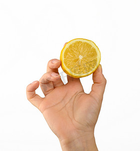 白色背景中，女手握着半个黄色柠檬