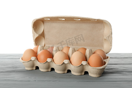 白色背景下木桌纸盒中的生鸡蛋很少