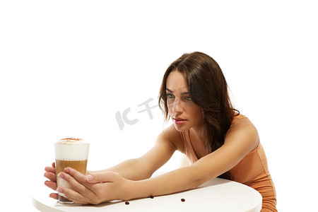 玛奇朵摄影照片_桌子另一边拿着拿铁玛奇朵咖啡的年轻女子