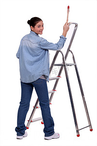 女性 DIY 风扇站着画笔和梯子