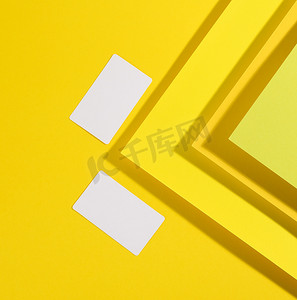 名片设计黄色摄影照片_创意黄色背景上的空白白色矩形名片，来自带阴影的纸片