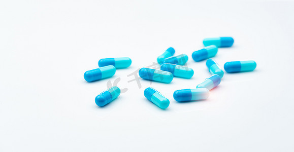 在白色背景上传播的蓝色抗生素胶囊药丸。