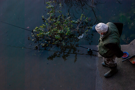 叔叔摄影照片_日落时分，叔叔在泰晤士河畔钓鱼。