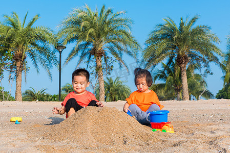玩1摄影照片_兄妹两个孩子搞笑挖沙子玩玩具