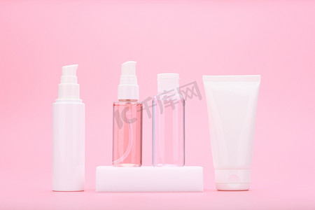 产品展板图摄影照片_一套美容产品，用于淡粉色背景下的日常抗痤疮皮肤治疗
