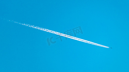 飞行痕迹摄影照片_飞机蒸汽痕迹划过蓝天