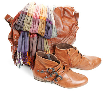 女性化的摄影照片_“棕色皮包、围巾和一双女性化的靴子”