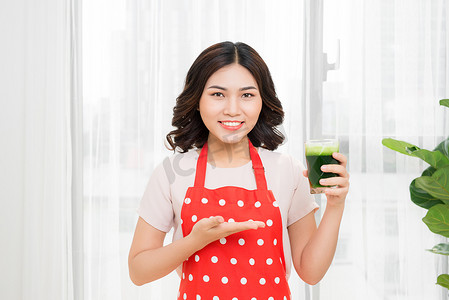 健康减肥享受生活摄影照片_年轻的亚洲女性享受健康的素食冰沙来减肥和排毒