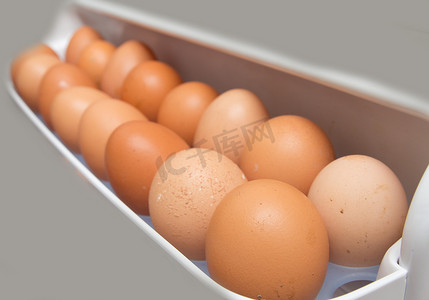 冰箱里摄影照片_冰箱里一堆棕色鸡蛋的特写