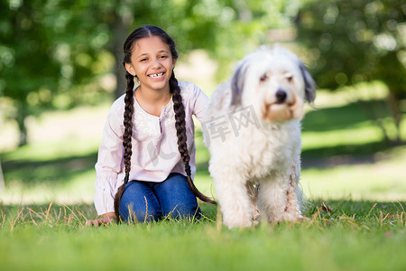 微笑的女孩和她的宠物狗玩耍的肖像
