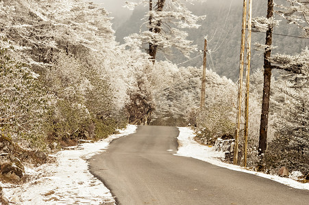 风雪同行摄影照片_冬天多风雪雾湿滑泥泞平坦的喜马拉雅山路。 