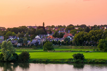 Rhenen 是荷兰的一个乡村小镇，日落时在水边的城市景观
