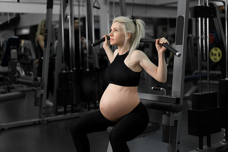 肩肌肉摄影照片_健身房锻炼孕妇运动服训练肩带运动机