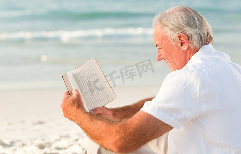 书的海洋摄影照片_男人在沙滩上看书