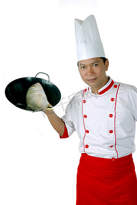 厨师把生鱼放在黑色煎锅上