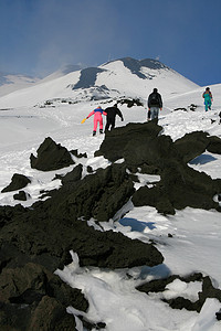 走在被雪覆盖的埃特纳火山上的人们