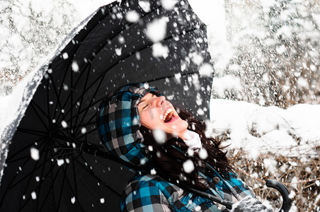 带伞摄影照片_暴风雪中带伞的年轻女子
