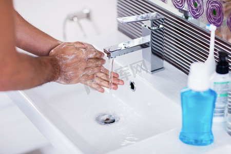 在流水下用肥皂洗手的特写