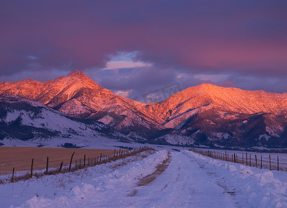 “冬季路，罗斯峰（中左，海拔 9,0004 英尺）和日落时的云彩，美国蒙大拿州加勒廷县”
