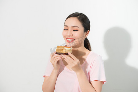 美丽的微笑亚裔年轻女子与孤立的白色背景上的巧克力蛋糕。