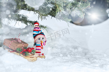 雪人礼物摄影照片_圣诞树下的圣诞作文 — 雪人、雪橇上装着礼物的盒子、文字位置、复制空间