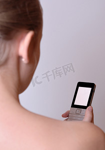 清晰连接摄影照片_一个年轻的女孩拿着一部显示屏清晰的手机。