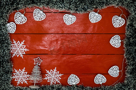 红色木板上的圣诞作文，配有圣诞花环和装饰品。