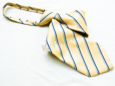 白色 backgr 上孤立的卷起条纹黄色和蓝色领带