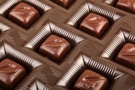 堆积图片摄影照片_白色背景中堆积的巧克力糖