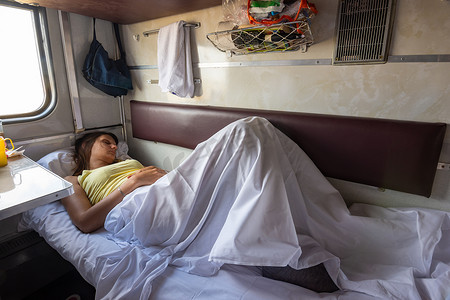 睡觉小女孩摄影照片_一个小女孩睡在火车车厢预留座位的下铺