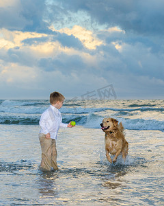 男孩和他的狗一起玩球
